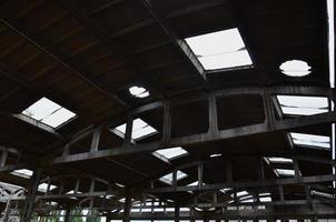 Landscape image of an abandoned industrial hangar with a damaged roof. Photo on wide-angle lens