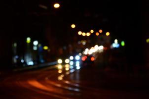 Blurred night scene of traffic on the roadway. Defocused image of cars traveling with luminous headlights. Bokeh Art photo