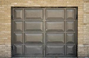 The texture of a painted metal gate from a brick garage photo