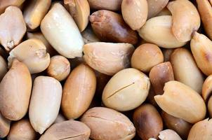 Peanut. A lot of small yellow nuts without peel. Background texture photo