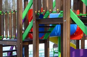 Fragment of a playground made of plastic and wood, painted in different colors photo