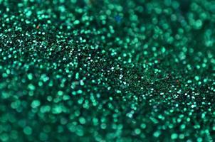 A huge amount of green decorative sequins. Background image with shiny bokeh lights from small elements photo