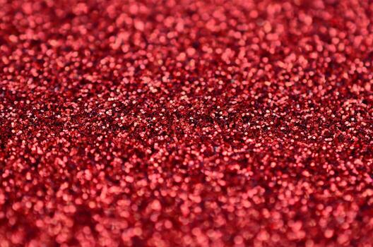 A huge amount of red decorative sequins. Background texture with shiny, small elements that reflect light in a random order. Glitter texture photo