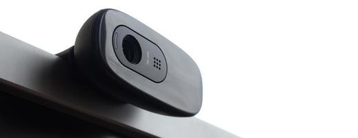 A modern web camera is installed on the body of a flat screen monitor. Device for video communication and recording of high quality video photo