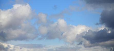 A blue sky with lots of white clouds of different sizes photo