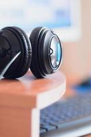 Big black headphones lie on the wooden desktop of the sound designer photo