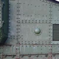 Texture of tank side wall, made of metal and reinforced with a multitude of bolts and rivets photo