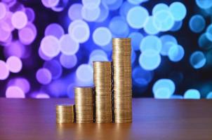 Golden coin stacks arranged as a graph. Increasing columns of coins photo