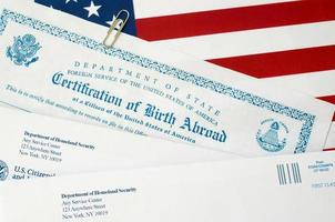 Fs-545 Certification of birth abroad lies on United States flag with envelope from Department of Homeland Security photo