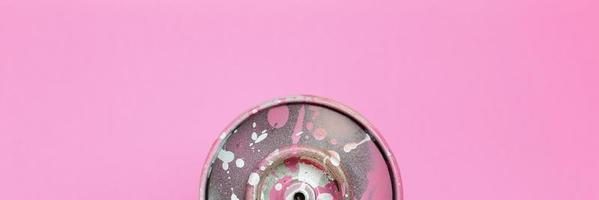 Used spray can with pink paint drips lie on texture background of fashion pastel pink color paper in minimal concept photo