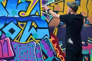 KHARKOV, UKRAINE - MAY 27, 2017 Festival of street arts. Young guys draw graffiti on portable wooden walls in the center of the city. The process of painting on walls with aerosol spray cans photo