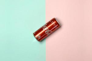 KHARKOV. UKRAINE - MAY 2, 2019 Flat lay shot single red drink tin can Coca Cola laying on pastel blue and coral background photo