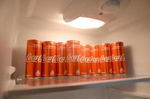 KHARKOV. UKRAINE - MAY 2, 2019 Coca-cola red soda drink cans inside domestic cooler fridge photo