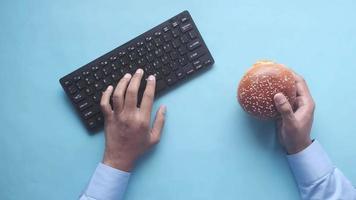 Having a burger while typing video