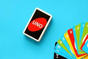 TERNOPIL, UKRAINE - MAY 15, 2022 Many colorful UNO game cards on blue background. UNO is an American shedding-type card game that is played with a specially printed deck photo