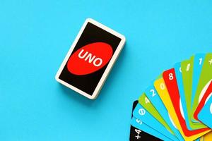 TERNOPIL, UKRAINE - MAY 15, 2022 Many colorful UNO game cards on blue background. UNO is an American shedding-type card game that is played with a specially printed deck photo