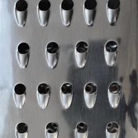 A fragment of a metal chrome grater close-up. Texture of blades for grinding food photo