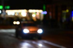 Blurred night scene of traffic on the roadway. Defocused image of cars traveling with luminous headlights. Bokeh Art photo