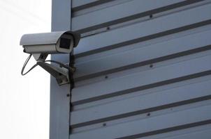 cámara de vigilancia blanca integrada en la pared metálica del edificio de oficinas foto