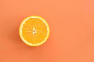 Top view of a one orange fruit slice on bright background in orange color. A saturated citrus texture image photo