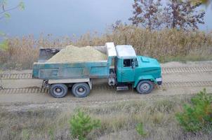 Dump truck transports sand and other minerals in the mining quarry. Heavy industry photo