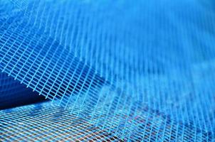 Close-up texture of a blue reinforcing mesh rolled up in a roll. Building resource for reinforcing walls in the process of their warming photo