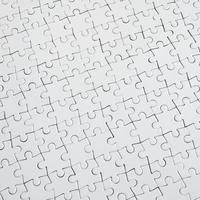 Close up texture of a white jigsaw puzzle in assembled condition. Top view. Many components of a large whole mosaic are united photo