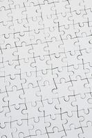 Close up texture of a white jigsaw puzzle in assembled condition. Top view. Many components of a large whole mosaic are united photo