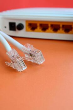 Internet router and Internet cable plugs lie on a bright orange background. Items required for Internet connection photo