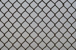 Texture of an old and rusty metal mesh on a neutral colored background photo