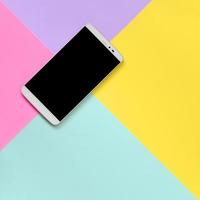 Modern smartphone with black screen on texture background of fashion pastel blue, yellow, violet and pink colors paper in minimal concept photo