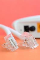 Internet router and Internet cable plugs lie on a bright orange background. Items required for Internet connection photo