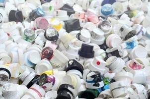 A pattern of many used and soiled nozzles from spray cans with aerosol paint. Background texture of the street art of drawing graffiti on the walls photo