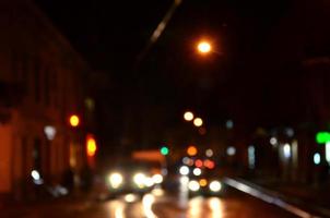 Blurred night scene of traffic on the roadway. Defocused image of cars traveling with luminous headlights. Bokeh Art photo