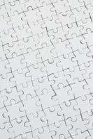 Close up texture of a white jigsaw puzzle in assembled condition. Top view. Many components of a large whole mosaic are united photo