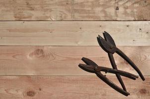 A few rusty scissors for metal lies on a wooden table in a workshop photo