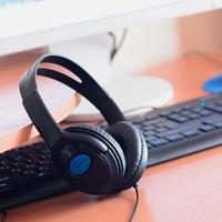 Big black headphones lie on the wooden desktop of the sound designer photo