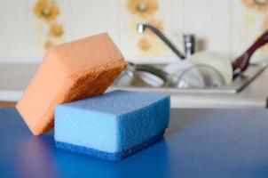 A few sponges lie on the background of the sink with dirty dishes photo