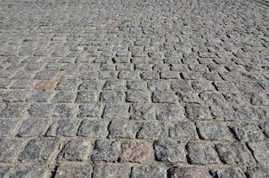 The texture of street alleys in the form of a mosaic made of processed paving stones in sunlight photo