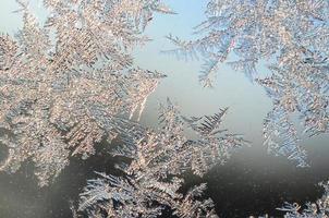 Snowflakes frost rime macro on window glass pane photo