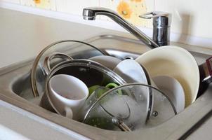 Dirty dishes and unwashed kitchen appliances filled the kitchen sink photo