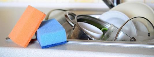 A few sponges lie on the background of the sink with dirty dishes photo