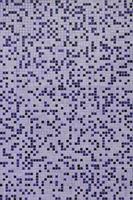 The texture of the wall, decorated with a mosaic of various small square tiles. Abstract pattern of ceramic tiles on the wall photo