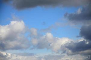 A blue sky with lots of white clouds of different sizes photo