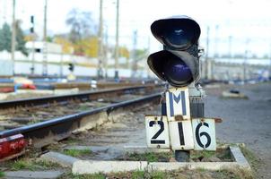 semáforo con luz azul ardiente. la intersección de las vías del tren foto