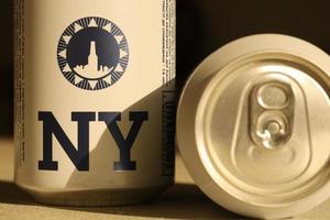 TERNOPIL, UKRAINE - JULY 18, 2022 Two cans of New Yorker fine lager beer with original logo and design on brown retro background photo