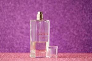 TERNOPIL, UKRAINE - SEPTEMBER 2, 2022 Yves Rocher Comme Une Evidence perfume bottle on shiny glitter background in purple colors photo