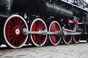 Red wheels of steam train photo