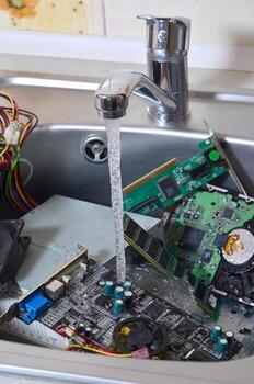 Hardware in kitchen sink under the water flow computer cleaning metaphoric concept photo