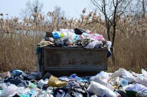 The garbage can is packed with garbage and waste. Untimely removal of garbage in populated areas photo